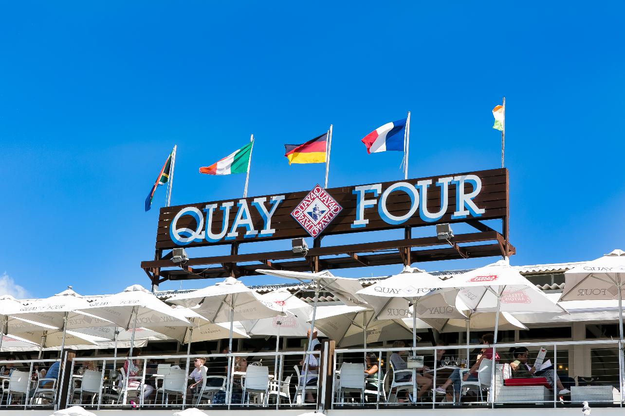Quay Four restaurant terrace with outdoor seating and flags