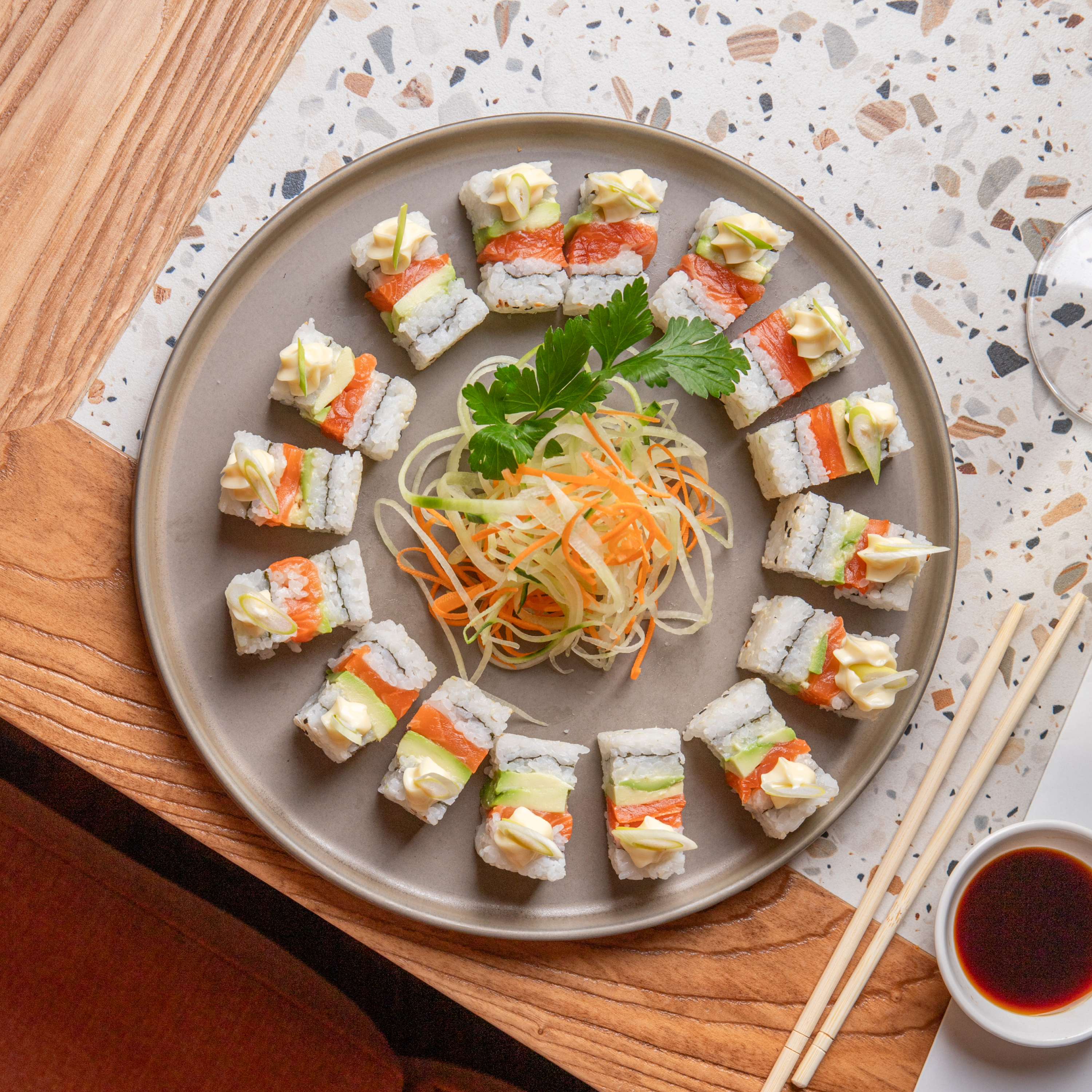 Sushi roll platter with pickled vegetable garnish and soy dipping sauce