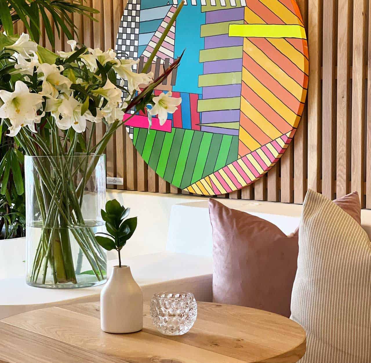Cozy seating area with colorful wall art and fresh lilies