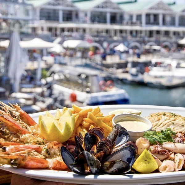 Seafood platter with mussels, prawns, fries and lemon at marina