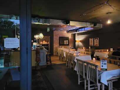 Indian Oven dining room with candlelit tables, white tablecloths and fairy lights