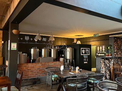 Charlie's Garage taproom interior with brewing tanks and rustic seating