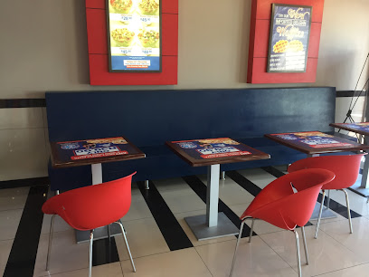 Roman's Pizza Plattekloof seating: blue bench, three tables with placemats, red chairs