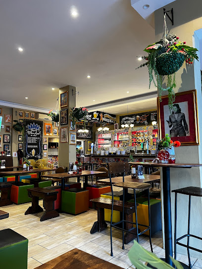 Fat Cactus Sea Point interior with colorful seating, hanging plants and bar