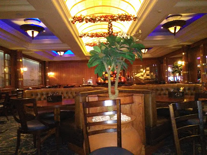 Quarterdeck Restaurant dining room with tufted booths, central plant, warm ceiling lights