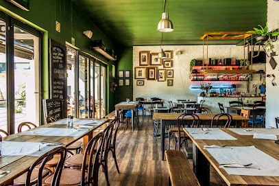Pizza Vesuvio dining room with green ceiling, wooden tables and bar