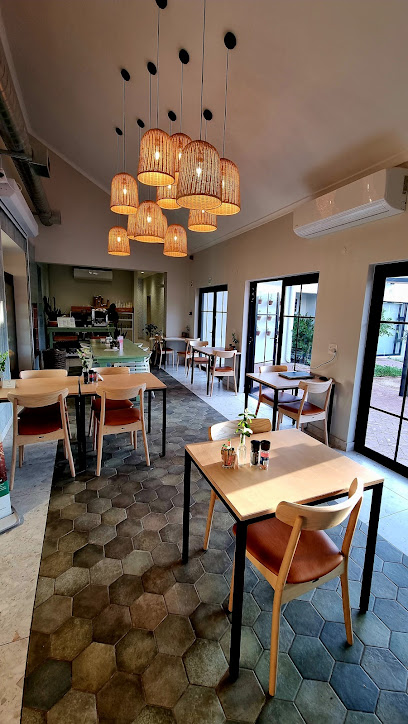 Real Food Co café interior with wooden tables and woven pendant lights