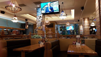Manitoba Spur interior with empty booths, wooden tables and hanging Western-style lamps