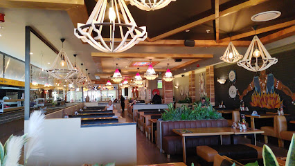 Indigo Spur dining room with booths, pendant lights, and mural