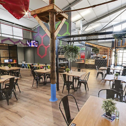 Freedom Adventure Park Tokai indoor dining area with wooden tables and metal chairs