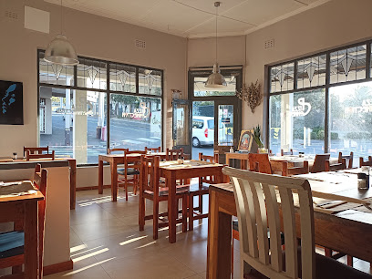 Pizza Connection interior in Cape Town - sunlit wooden tables and chairs