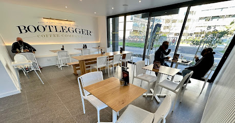 Bootlegger XS Pinelands café interior with logo, wooden tables and seated customers