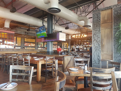 PRIMI Table View dining area with wooden tables, chairs and bar