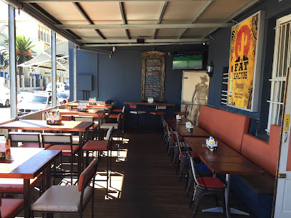Covered outdoor dining patio at The Fat Cactus Woodstock with wooden tables and bench seating