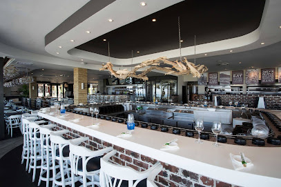 Cape Town Fish Market Bloubergstrand interior with central sushi bar and white stools