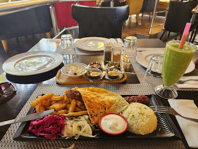 Ala Turkish table with kebab platter, rice, sides, dips and green smoothie
