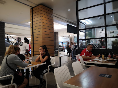 Customers eating at KAUAI Kenilworth Centre café, smoothies and wraps visible
