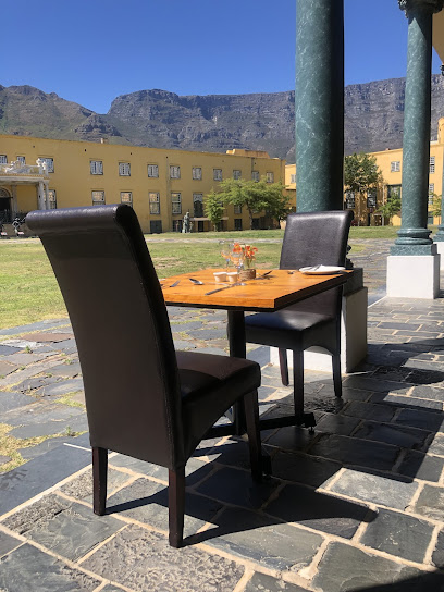 Salaam Mnandi Restaurant outdoor table with two chairs in courtyard, mountain backdrop