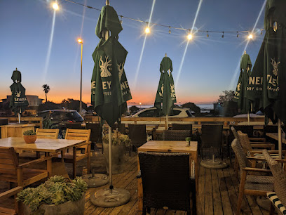 The Hart outdoor deck at sunset with string lights and closed umbrellas
