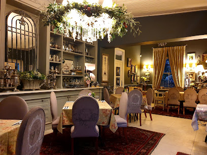 Chocolat Bistro cozy dining room with chandelier, upholstered chairs and set tables