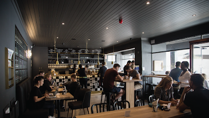 Busy Bootlegger Bakoven café interior with customers at tables and baristas behind the counter