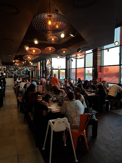 Busy RocoMamas N1 City interior with communal tables and pendant lights