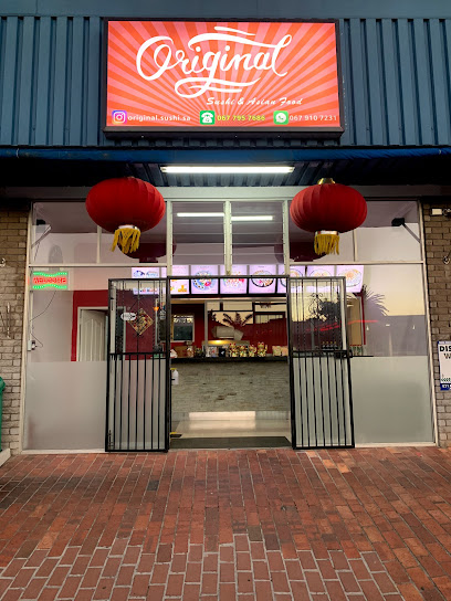 Original Sushi storefront with illuminated red sign and hanging red lanterns