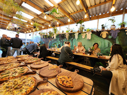 Pizzasaurus Cape Town patio with communal benches and pizza boards
