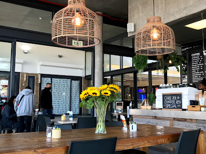 Valley Roast Coffee Co interior with long communal table, sunflowers, and counter.