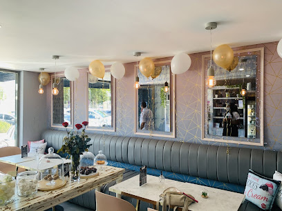 Serendipity Creamery cozy interior with banquette seating, marble tables, balloons
