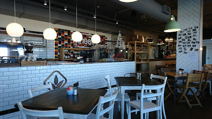 Knead Bakery interior with white-tiled counter, hanging globe lights, and seating