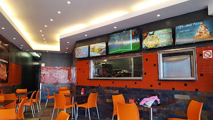 Bin Rashied Grassy Park interior with orange chairs and lit menu boards