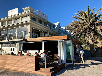 The Beach Bar in Cape Town with outdoor seating, diners and a palm tree