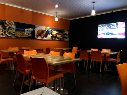 Bin Rashied Kenilworth dining area with orange chairs, wooden tables, wall art and TV