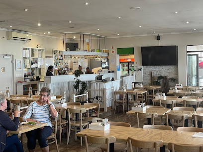 The Beachcomber Bistro interior with wooden tables, service counter, and seated patrons