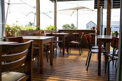 I Love Melkies outdoor wooden deck seating with tables and umbrellas