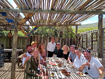 The Kelp Shack guests dining at outdoor wooden table under pergola