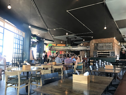 Taproom Salt River interior with bar, wooden communal tables and seated diners