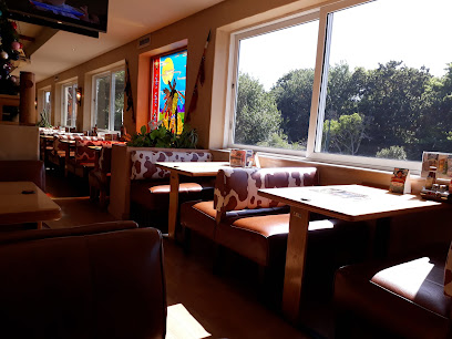 Golden Spur Cape Town dining booths with cow-print seats and sunlit windows