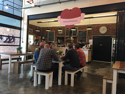 Mill & Press Café interior, Masons Press building, customers at communal table, heart sign '#sharethelove'