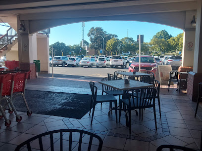 Covered outdoor seating at Mugg & Bean Durbanville overlooking parking lot