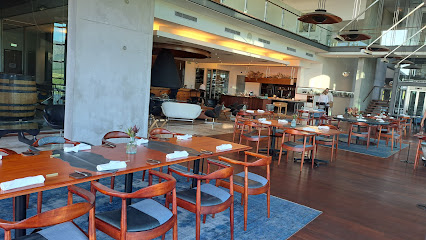 Chorus Restaurant dining room in Cape Town with wooden tables, blue-cushioned chairs and open bar