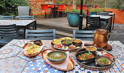 Thali Restaurant outdoor table with Indian thali dishes and copper jug