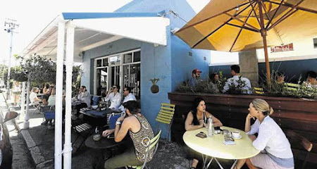 The Blue Cafe outdoor seating on a sunny day with people enjoying coffee