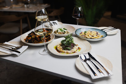 Therapy Restaurant table with plated dishes, two wine glasses and cutlery