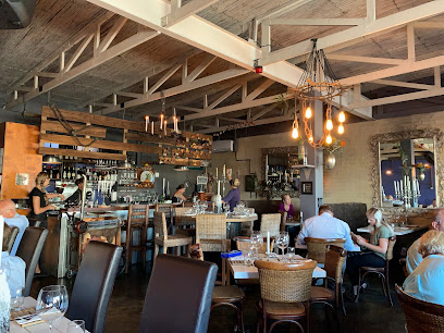 Homespun Blouberg dining room with seated diners, bar and warm pendant lights