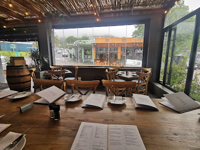 Bacini’s Pizzeria & Deli communal wooden table set with menus and plates