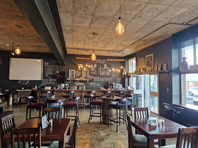 The Hickory Shack Simons Town interior with wooden tables, bar, chalkboard menu