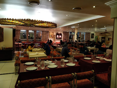 Vintage India dining room with diners, set tables and warm lighting