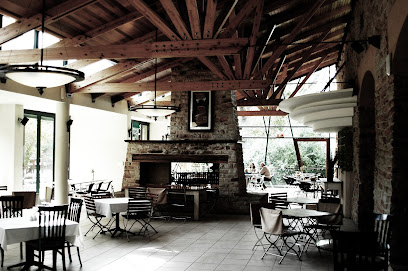 Fynkos dining room with exposed wooden beams, stone fireplace and set tables